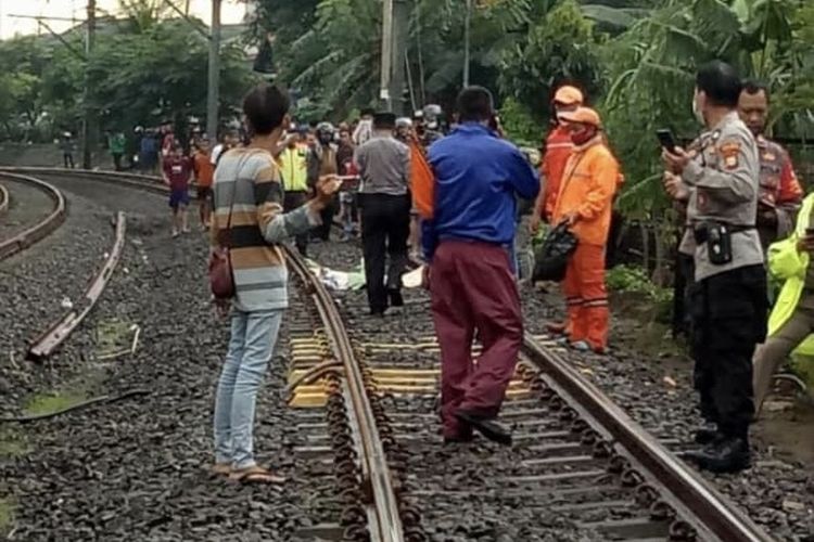 Anggota Polsek Pesanggrahan menangani kecelakaan yang melibatkan seorang remaja di lintasan kereta api di wilayah RT 010/01, Pesanggrahan, Jakarta Selatan pada Selasa (9/3/2021) sore. Foto: Kompas.com